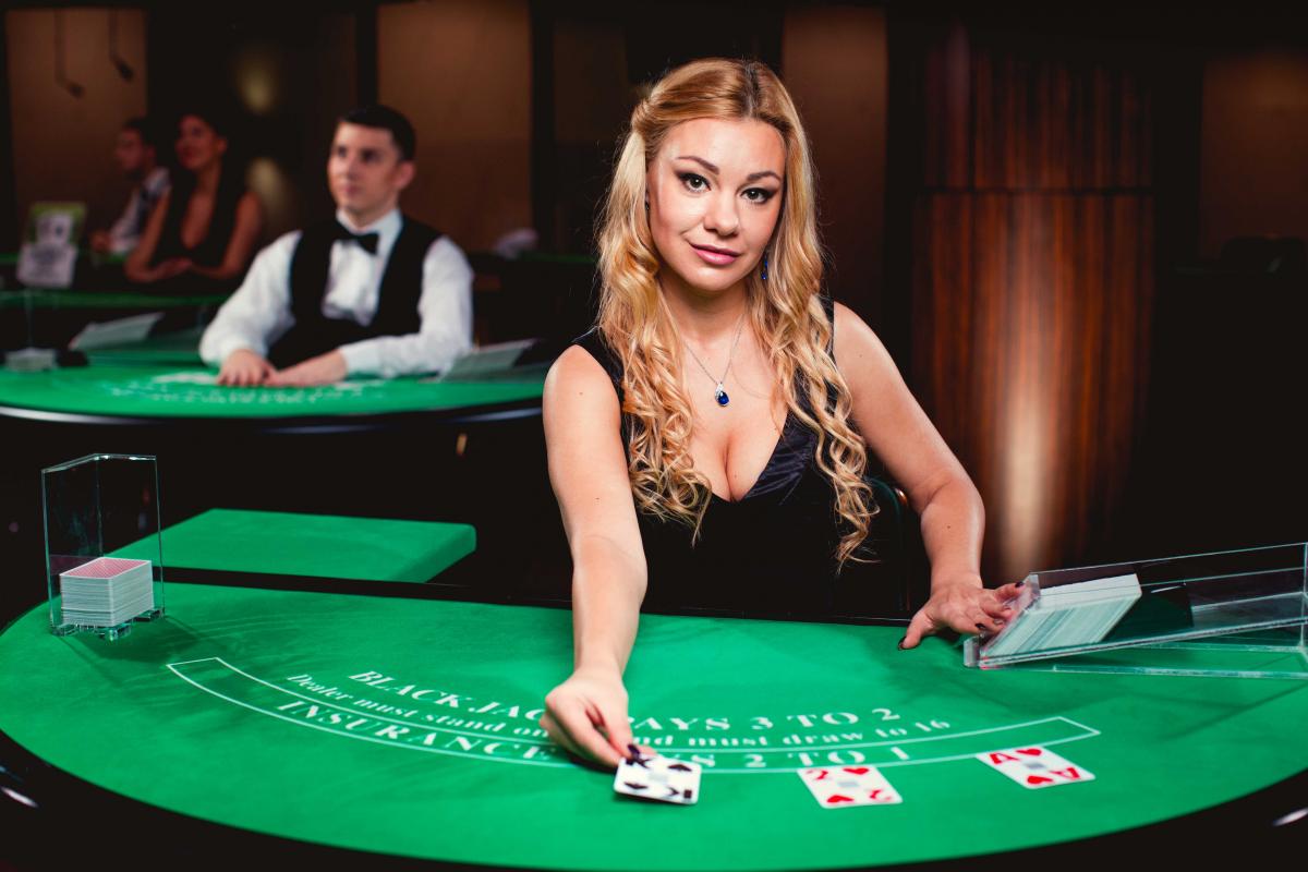 Live Blackjack dealer is dealing card on a blackjack table