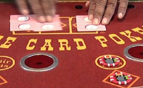 image of the proprietary game Three Card Poker, where the edge of each dealer card can be observed